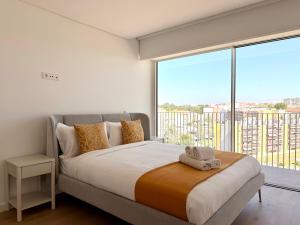 a bedroom with a large bed with a large window at Nooba Barreiro Apartment in Barreiro