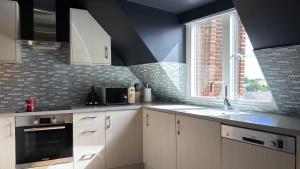 a kitchen with white cabinets and a sink and a window at The Apex Penthouse, Hyde Park in London
