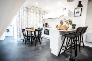 a kitchen with black chairs and a white counter top at Flandres Appart' Hotel - Schepers in Lille