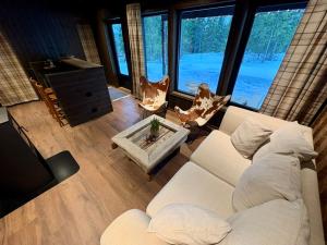 a living room with a white couch and a large window at Mountain Stable Apartment Beito in Beitostøl
