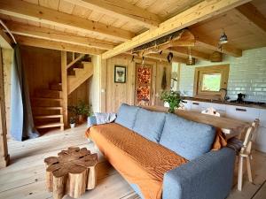 a living room with a blue couch in a cabin at Górska Osada Berdo in Chmiel