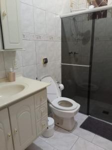 a bathroom with a shower and a toilet and a sink at Suíte Gigá 1 in Brotas