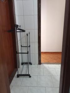 a room with a white tiled floor with a stand up shower at Suíte Gigá 1 in Brotas +1 photo