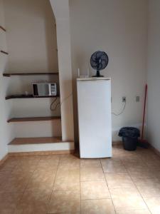 a kitchen with a white refrigerator in a room at Suíte Gigá 1 in Brotas
