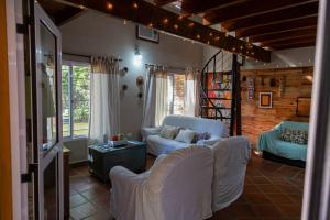 a living room with white couches and a table at Casa Paso de la Patria in Corrientes