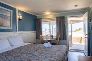 a bedroom with a bed with a table and a window at Colonial Inn in Nags Head +116 photos
