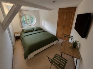 a bedroom with a green bed and a table at Hostelion in Magdeburg