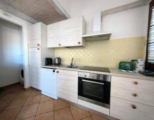 a kitchen with a sink and a stove top oven at The pool house - Il Gabbiano in Palau