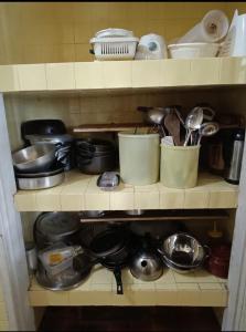 a shelf filled with pots and pans and utensils at Casa Areal in Araruama