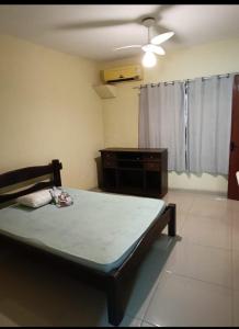 a bedroom with a bed and a ceiling fan at Casa Areal in Araruama