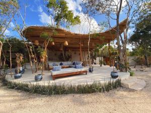 a wooden pavilion with a couch in a yard at Kasa UhMay Tulum in Francisco Uh May