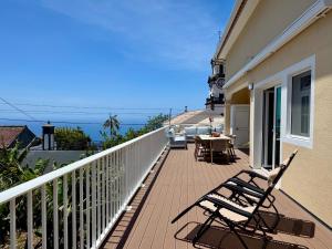 a balcony with chairs and a table on a house at Casa Neves in Arco da Calheta