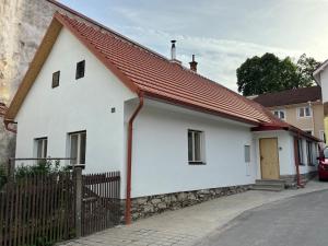 a white house with a red roof on a street at BrezINNa - 200 let historie - moderní chalupa in Počátky