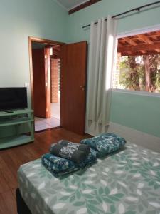 a bedroom with a bed and a flat screen tv at Suíte GiGá 2 in Brotas