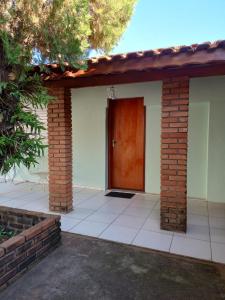 a house with a red door and a brick wall at Suíte GiGá 2 in Brotas