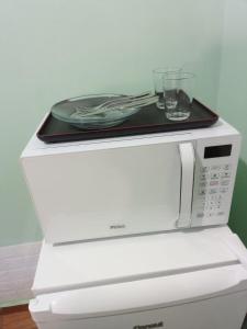 a microwave with a plate on top of it at Suíte GiGá 2 in Brotas