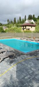 a swimming pool with lounge chairs and a house at котедж петриківка З червня басейн з підігрівом 10 на 5 метрів in Slavske
