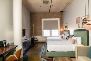 a bedroom with two beds and a desk and a television at Canvas Hotel Dallas in Dallas