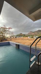a plunge pool with a view of a field at Avera luxurious stay in Igatpuri