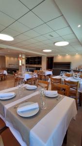 a dining room with tables and chairs with white table linen at Hotel Atlántico Sanxenxo in Montalvo