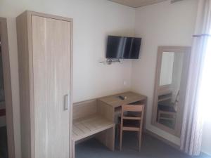 a room with a desk and a mirror and a television at Hotel De La Mer in Saint Malo