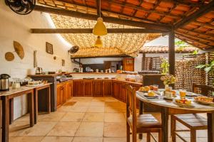 a large kitchen with wooden cabinets and a table at Villa Medina Oasis in Jericoacoara +88 photos