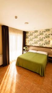 a bedroom with a bed with a green blanket at Hotel Atlántico Sanxenxo in Montalvo +45 photos
