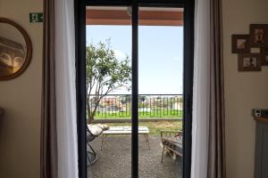 a sliding glass door with a view of a patio at Bella Vista Studio in Canhas