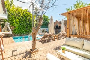 a patio with a couch and a pool at NURİYE ALACATI in Alaçatı