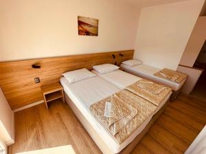 two beds in a small room with wooden floors at Apartments Kristic in Neum