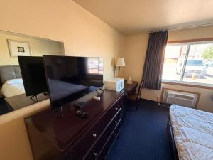 a hotel room with a dresser with a flat screen tv at East Grand Inn Grand Forks ND I 29 in East Grand Forks