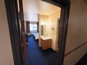 a room with a bathroom with a sink and a bed at East Grand Inn Grand Forks ND I 29 in East Grand Forks +65 photos