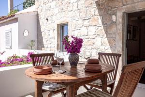 a wooden table with chairs and a vase with purple flowers at Central Art House Hvar in Hvar +33 photos