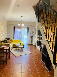 a living room with a yellow couch and a staircase at Afytos house in Afitos +39 photos