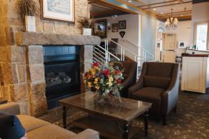 a living room with a fireplace and a table at The Landing Hotel in Ketchikan