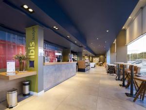 a restaurant with tables and chairs and a bar at Ibis Budget Farroupilha in Farroupilha