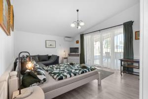 a living room with a bed and a couch at Gery Apartman in Zamárdi