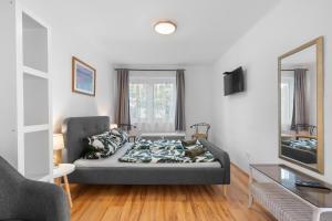 a bedroom with a bed and a couch and a mirror at Gery Apartman in Zamárdi