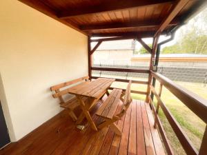 a wooden bench and a table on a balcony at Zieleniec in Drawsko +3 photos