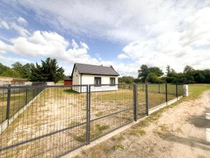 a fence in front of a white house at Zieleniec in Drawsko