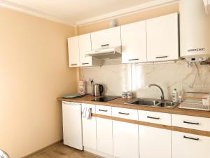 a kitchen with white cabinets and a sink at Zieleniec in Drawsko