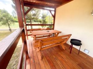 a porch with a wooden bench and a table at Zieleniec in Drawsko