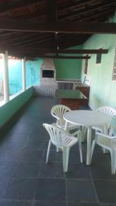 a white table and chairs on a patio at Edícula Gigá in Brotas +20 photos