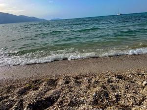 a beach with the ocean and a boat in the water at Lunea Apartment Palm Residence in Vlorë