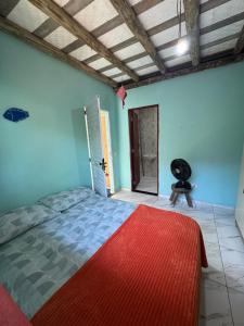 a bedroom with a bed and a chair in a room at Chalé in Paraty