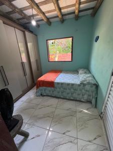 a bedroom with a bed in a room with a window at Chalé in Paraty