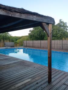 a wooden deck next to a swimming pool at Gite du gachou in Souillac