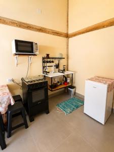 a kitchen with a stove and a sink and a refrigerator at Chalés & Suítes Praia Barequeçaba I Cozinha Compacta in São Sebastião