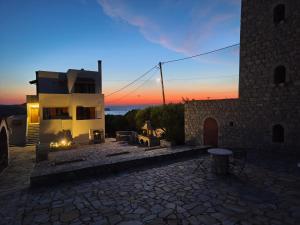 a building with a fire pit in front of a sunset at Casa Stella in Mézapos
