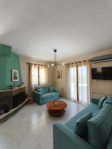 a living room with two blue couches and a table at Casa Stella in Mézapos